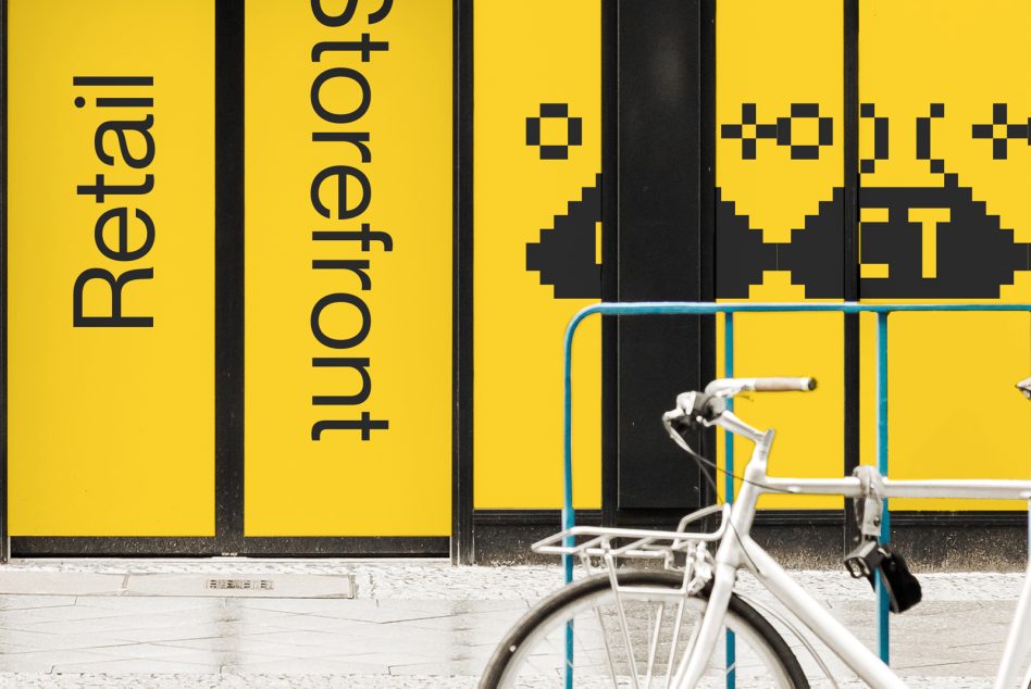 Retail storefront mockup with pixel art design elements and white bicycle, showing storefront branding in a real-world setting for designers.